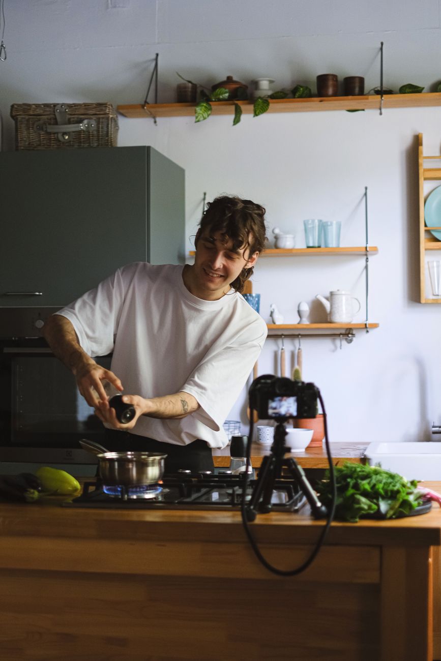Creator recording a cooking vlog in his kitchen